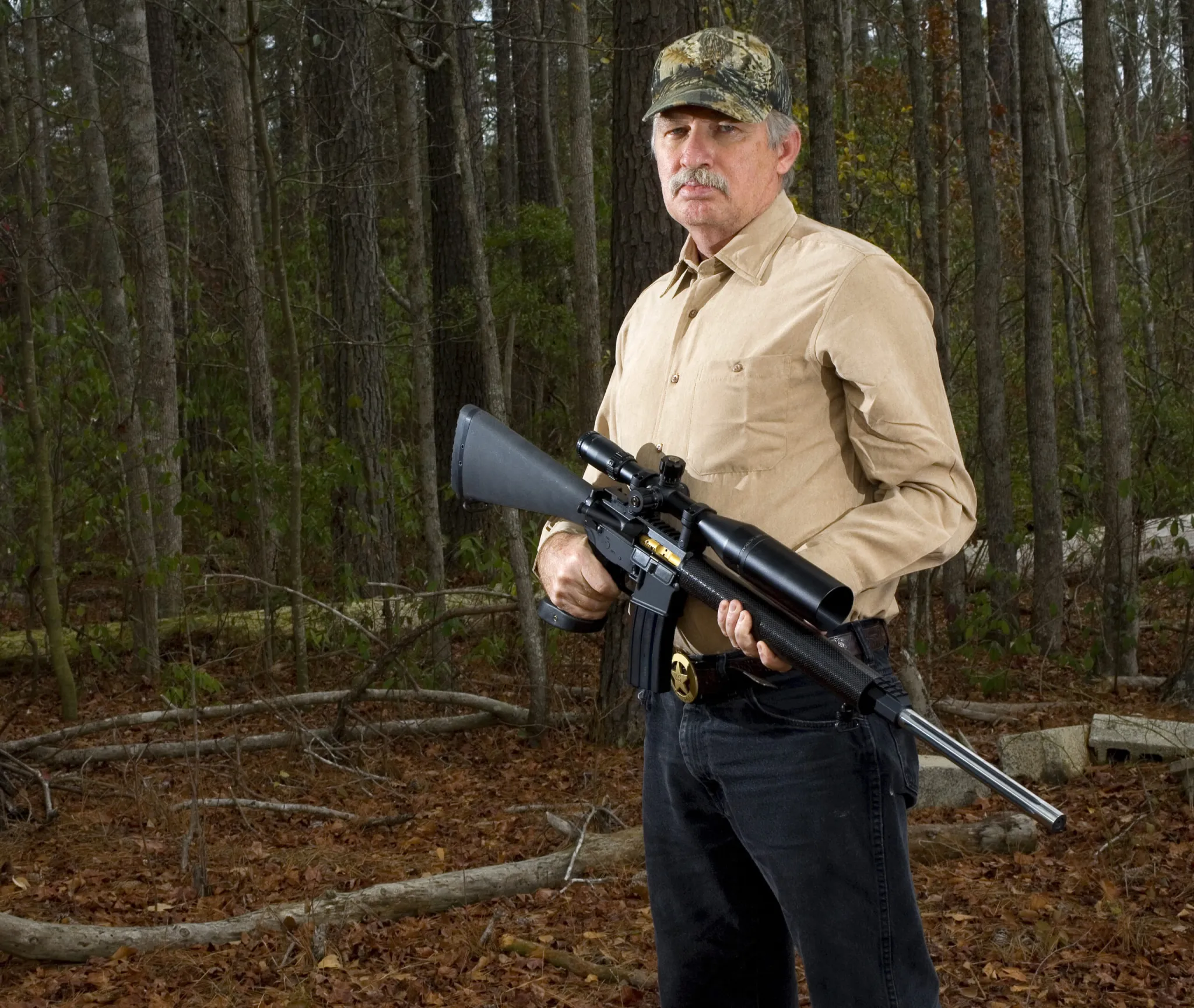 AR-platform hunting rifle with scope and bipod set up in a field