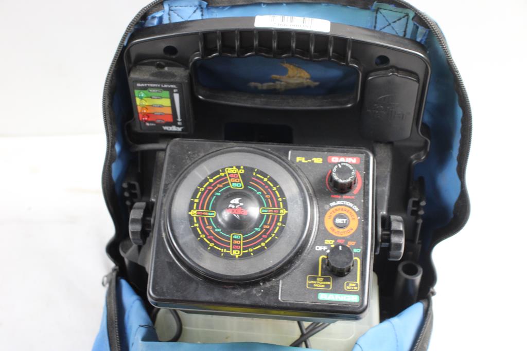 Ice fishing flasher unit displaying sonar returns inside a portable ice shelter on a frozen lake