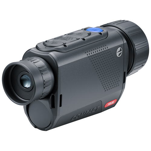 Hunter scanning a dark field with a handheld thermal monocular during a nighttime predator hunting setup