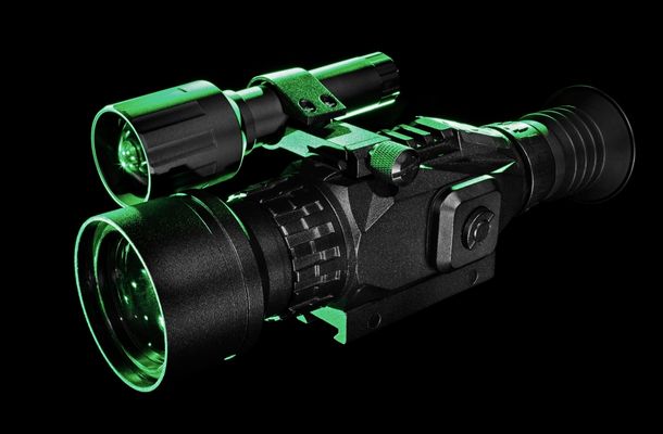 Thermal scope mounted on a rifle overlooking a dark field used for nighttime hog hunting