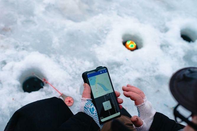 Ice fishing flasher and fish finder unit displayed side by side in an ice shelter