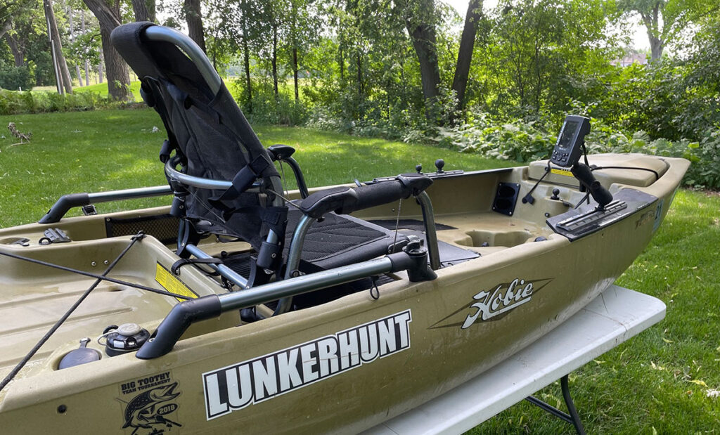 Hobie Pro Angler 14 and Old Town Sportsman 120 side by side on a lake shore
